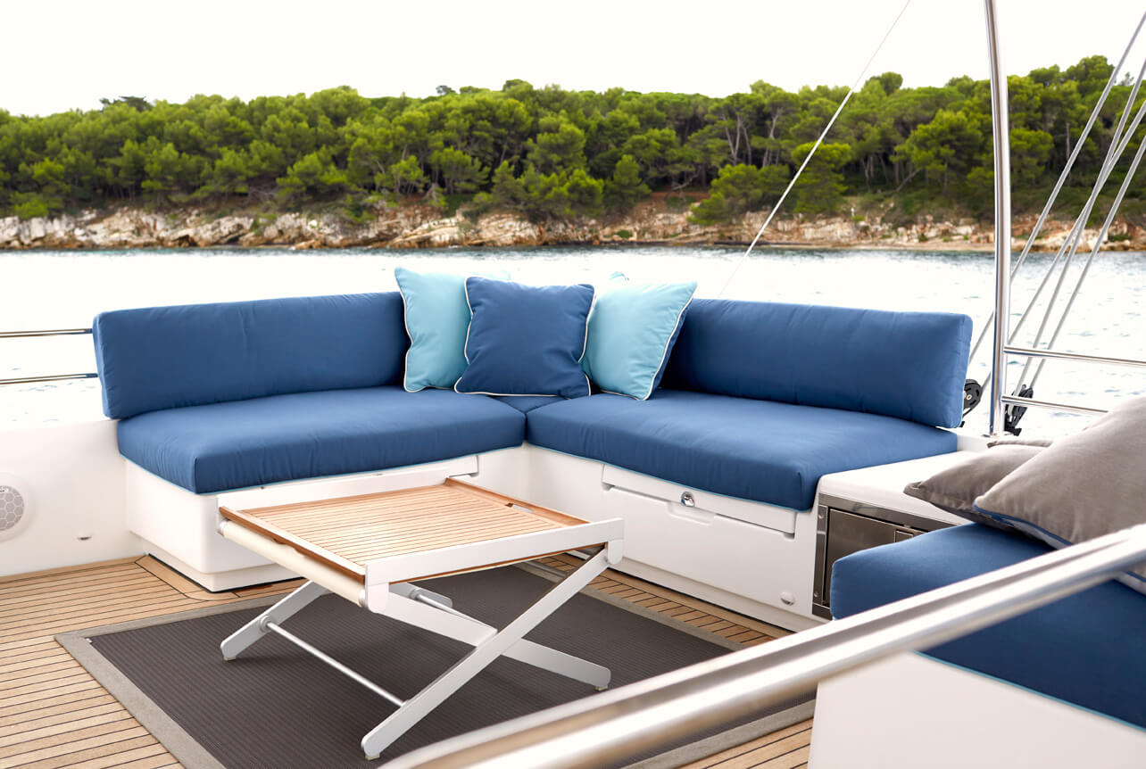 Exterior seating area on a catamaran with cushions covered in blue Sunbrella fabrics
