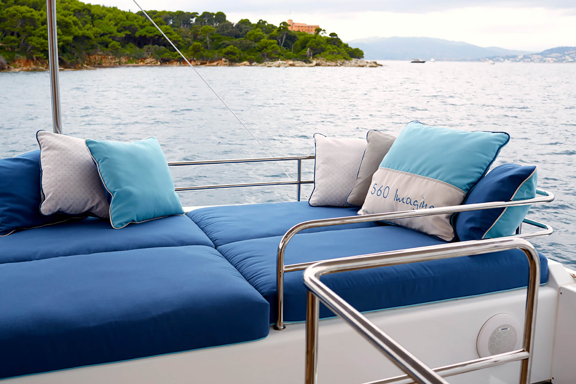 水景下，采用 Sunbrella 织物制成的蓝色坐垫与枕头