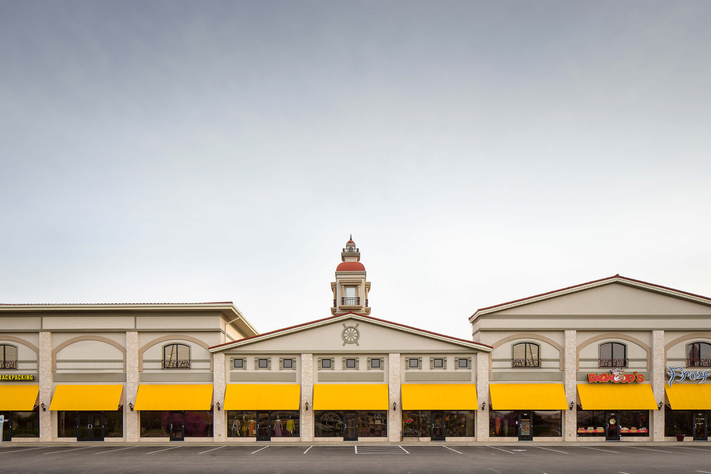 Yellow fixed frame awning made with Sunbrella Clarity fabric at shopping center