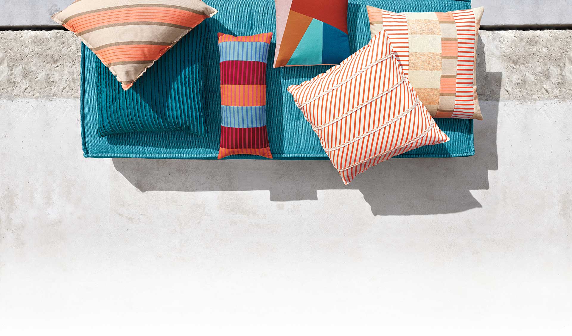 Close-up photo with teal floor cushion with pillows.